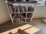 a bookshelf in the corner of a room with a lot of books on it