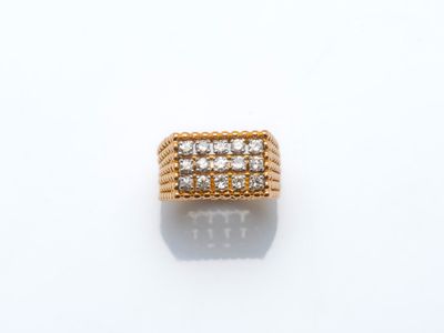 une bague en or et diamants posée sur une surface blanche
