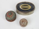 three small metal objects sitting on top of a white surface