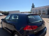 the back end of a blue volkswagen golf parked in a parking lot