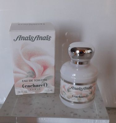 un flacon de parfum posé sur une étagère à côté d'une boîte