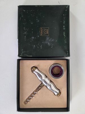 a bottle opener in a box with a corkscrew in it