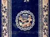 an oriental rug with a blue background and a gold border