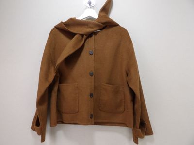 brown wool jacket with hood on hanger on white wall