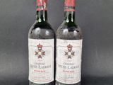 two bottles of chateau petit lagrave wine on a black background