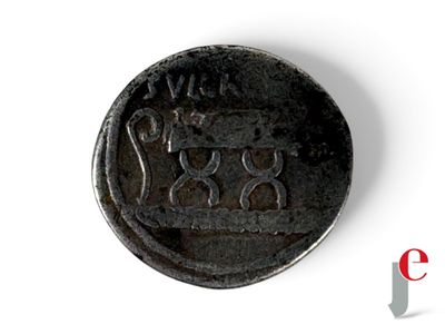 une vieille pièce de monnaie sur laquelle figure une couronne, posée sur une surface blanche