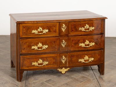 a wooden chest of drawers with gold decorations on it