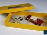 a yellow box with a toy car and a toy truck in it