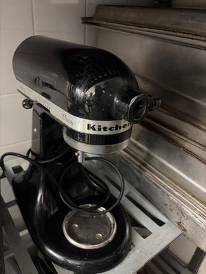 a black and silver mixer sitting on top of a stove