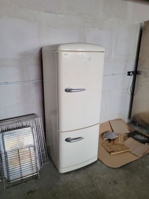 a white refrigerator next to a heater in a room