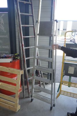 un homme qui se tient à côté d'un échelle