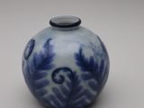 a small blue and white vase with a black lid