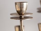 a silver candle holder that has a cup on it