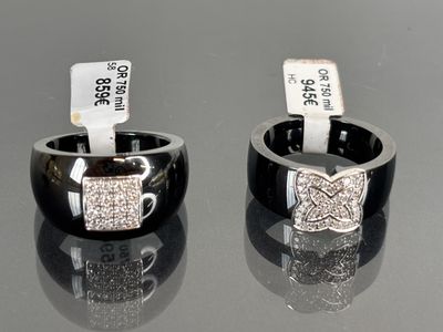 pair of black and white rings with diamonds on them sitting on a table