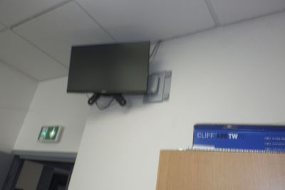 un téléviseur à écran plat fixé au mur d'une pièce