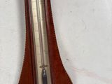 a wooden clock that is on the wall with a thermometer