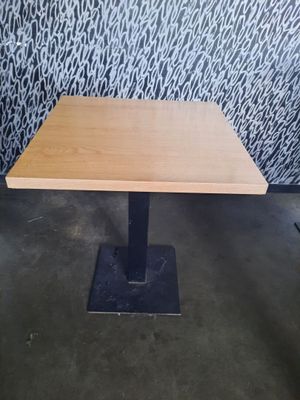 une table en bois avec un piètement en métal, placée devant un mur