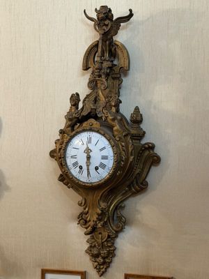 une horloge accrochée au mur à côté d'un tableau