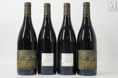 four bottles of wine are lined up on a white surface