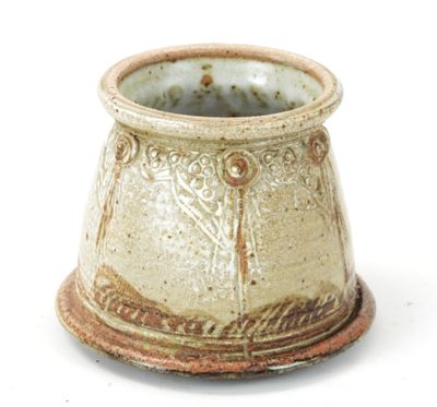 a close up of a small vase on a white surface