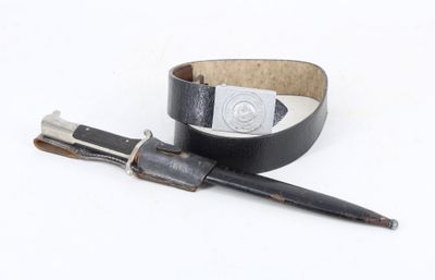 a pen and a leather belt on a white surface