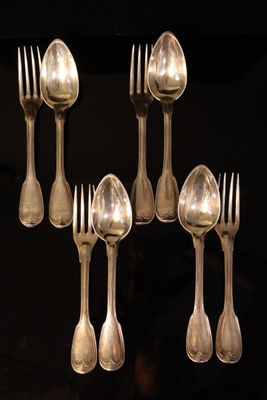 six silver spoons and six silver spoons on a black table