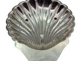 a silver shell shaped bowl sitting on a white surface