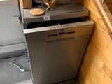 un lave-vaisselle dans un coin de la cuisine, près de l'escalier