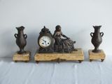three vases and a clock sitting on a table