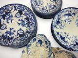 several blue and white plates are arranged in a circle on a white surface
