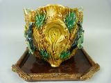 a yellow and green vase sitting on a brown tray