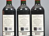 three bottles of red wine sitting on top of a table