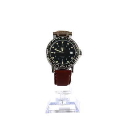 une montre posée sur un support sur une surface blanche