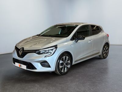 Une voiture argentée est garée dans une pièce blanche