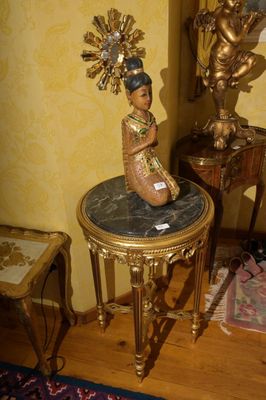une statue de femme assise sur une table