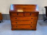 une commode en bois dans une pièce où se trouve une chaise