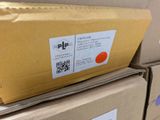 a box with a sticker on it sitting on top of a pile of boxes
