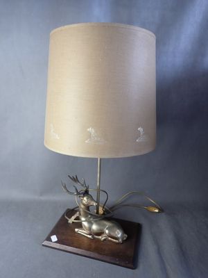 an image of a lamp with a deer on it on a wooden base