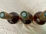 three bottles of beer sitting on a white surface