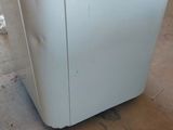 a white refrigerator sitting in a room with a yellow sticker on it