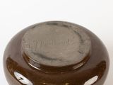 a brown vase sitting on a table with a white background