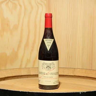 a bottle of wine sitting on top of a barrel