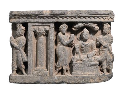 une sculpture en pierre représentant un groupe de personnes sur un socle