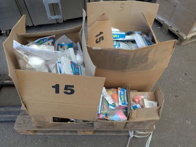 two boxes full of toothbrushes and toothpaste on a cart