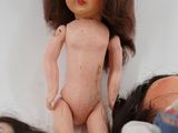 three dolls sitting next to each other on a bed