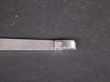 a small metal object on a table with a black background