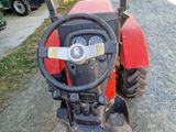 un tracteur rouge garé sur le bord de la route