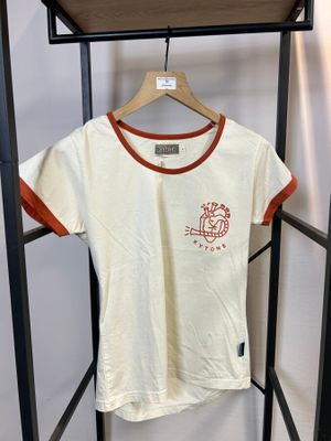 un t-shirt blanc avec une bordure orange, suspendu à un cintre dans la chambre