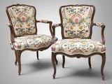paire de fauteuils de style Louis XV aux accoudoirs rembourrés d'un motif floral