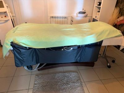 un lit recouvert d'un drap, dans une chambre